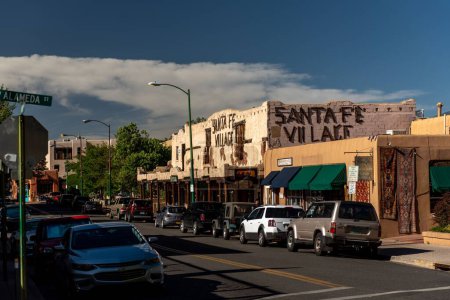 Téléchargez les photos : Une journée ensoleillée dans une rue animée du centre-ville de Santa Fe avec des voitures garées près des trottoirs - en image libre de droit