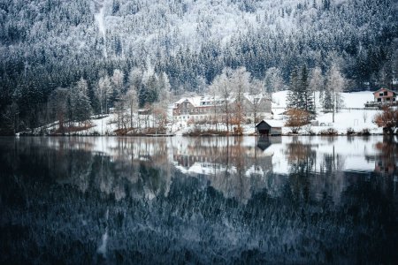 Téléchargez les photos : Une rivière cristalline reflétant les montagnes rocheuses et une forêt en hiver - en image libre de droit