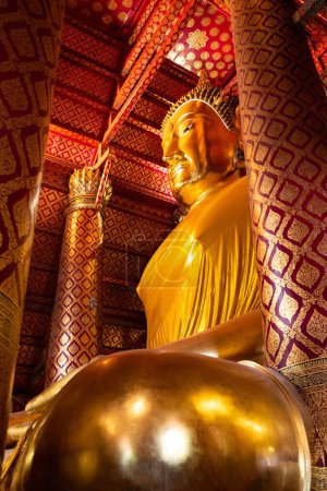 Photo for A vertical low angle shot of a big golden Buddha statue in a temple in Ayutthaya, Thailand. - Royalty Free Image