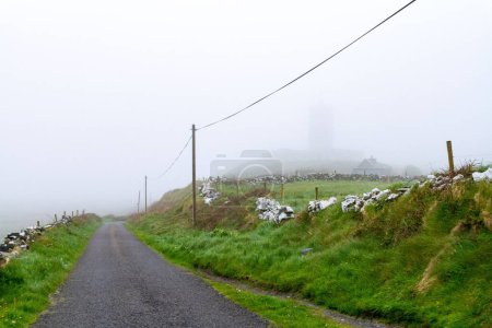 Photo for A landscape with a rural road in Doolin on a foggy day, Ireland - Royalty Free Image