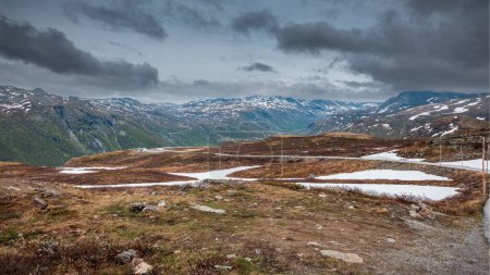 Téléchargez les photos : Un beau cliché d'une vallée sèche près des montagnes enneigées à Tindeveien, Norvège - en image libre de droit