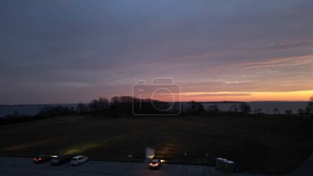 Photo for A Drone shot of splendid sunset over the sea and parked cars on its coast in Rhode Island, USA - Royalty Free Image