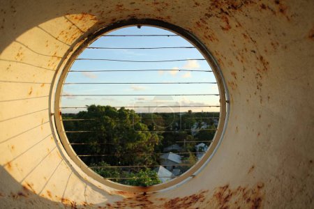Foto de Una ventana cerrada oxidada redonda al parque verde - Imagen libre de derechos