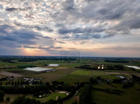 Photo for The green fields with trees and the windmills in a distance at scenic sunset - Royalty Free Image