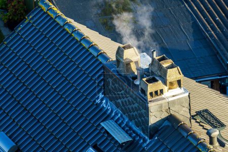 Foto de Un dron disparó sobre un tejado tradicional de azulejos con una chimenea humeante - Imagen libre de derechos