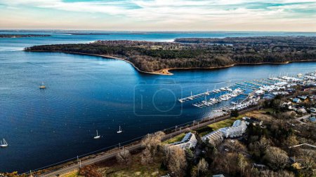Photo for A drone shot of a scenic sea with boats on its harbor and houses on the coast, cool for background - Royalty Free Image