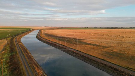 Foto de Un paisaje aéreo de un río a través de un campo cultivado en un amanecer de ensueño - Imagen libre de derechos