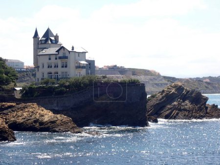 Téléchargez les photos : Vue panoramique d'une maison blanche sur une falaise rocheuse sur la côte d'une mer - en image libre de droit