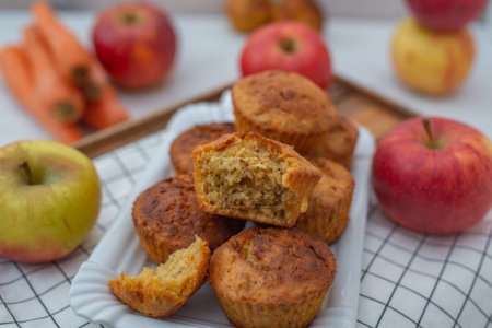 A closeup of an apple carrot muffin with a blurred apple background