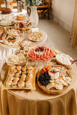 Téléchargez les photos : Un plan grand angle de tables de banquet pleines de nourriture magnifiquement décorée, prêt pour un événement - en image libre de droit