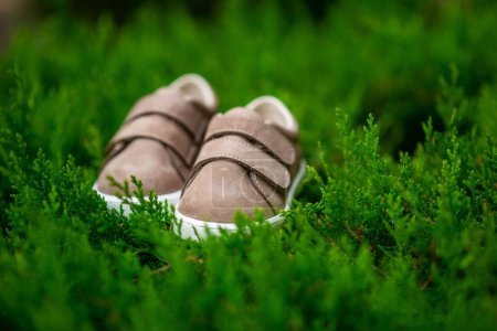Téléchargez les photos : Une mise au point sélective d'une paire de chaussures pour enfants sur une herbe verte - en image libre de droit
