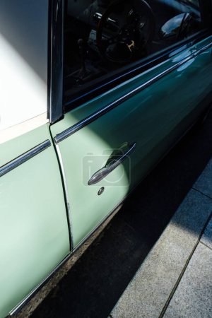 Foto de Un disparo vertical de un coche verde vintage detalles en la calle - Imagen libre de derechos