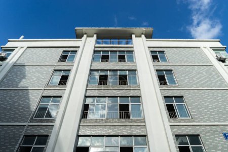 Photo for A low-angle shot of the building's facade against the background of the blue sky. - Royalty Free Image