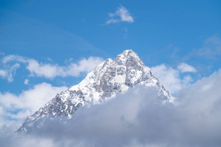 Téléchargez les photos : Une vue magnifique sur un sommet enneigé entouré de nuages par une journée ensoleillée - en image libre de droit