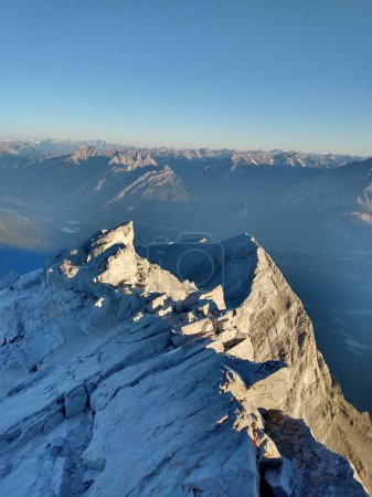 Téléchargez les photos : Vue aérienne verticale d'un sommet de montagne sous un ciel bleu en Alberta, Canada. - en image libre de droit