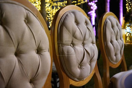 Téléchargez les photos : Un gros plan de trois chaises modernes avec des boutons placés dans une rangée dans un restaurant - en image libre de droit