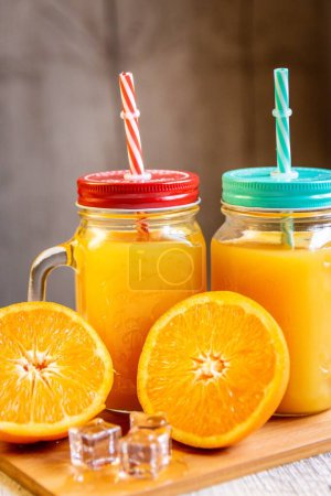Photo for The Mason jar with orange lemonade on the table, close-up - Royalty Free Image
