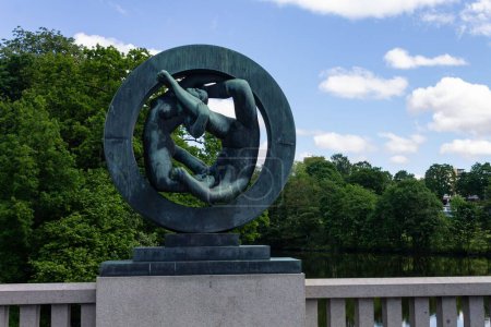 Téléchargez les photos : Une sculpture moderne dans le parc Vigeland à Oslo, Norvège capturée contre les arbres feuillus et le ciel bleu - en image libre de droit