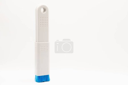 Téléchargez les photos : Gros plan d'une brosse en plastique pour PC avec poils en nylon bleu sur fond blanc - en image libre de droit