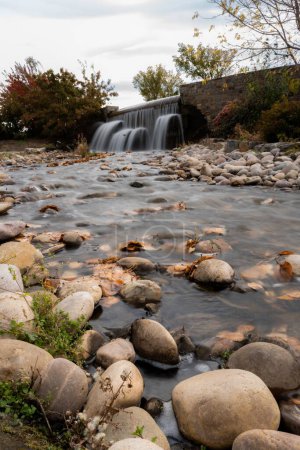 Téléchargez les photos : Un plan vertical d'un ruisseau rocheux avec une belle cascade coulant dans le dos - en image libre de droit