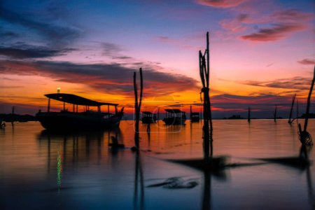 Téléchargez les photos : Un magnifique coucher de soleil sur la mer avec des bateaux près de Belitung Island, Indonésie. - en image libre de droit