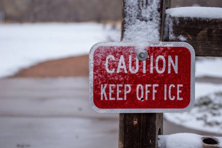 Téléchargez les photos : Un gros plan d'un panneau de mise en garde avec l'inscription tenir à l'écart de la glace couverte de neige - en image libre de droit