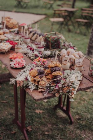 Téléchargez les photos : Un gros plan vertical d'une table de fête à l'extérieur dans le parc avec des bonbons et des fleurs - en image libre de droit