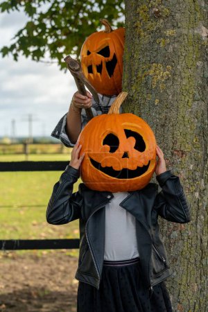 Photo for A vertical shot of people with carved pumpkin heads. - Royalty Free Image