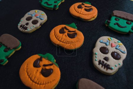 Téléchargez les photos : Un gros plan de cookies Halloween en fond noir - en image libre de droit