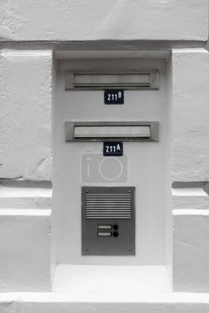 Photo for A grayscale vertical shot of letterboxes and intercom in old plastered wall - Royalty Free Image