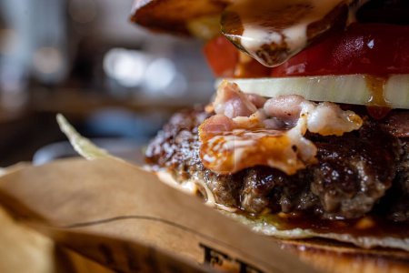 Foto de Un primer plano de una hamburguesa de carne de res con fondo borroso - Imagen libre de derechos