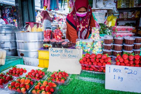 Photo for A Strawberry vendor at a wet market in Cameron Highlands in Pahang, Malaysia - Royalty Free Image
