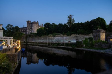 Téléchargez les photos : Le pont Kilkenny et le château reflétés dans la rivière le soir - en image libre de droit