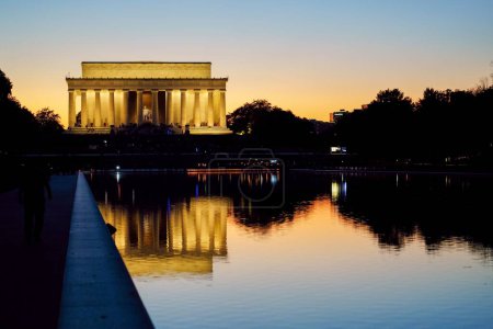 Photo for A sunset behind the Lincoln Memorial as crowds still gather on the steps - Royalty Free Image