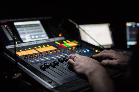 Téléchargez les photos : Un bureau de mixage de sons entre les mains d'un homme utilisé à la représentation du Dr Hook au théâtre Aylesbury Waterside - en image libre de droit