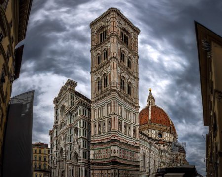 Photo for A low-angle of cathedral Di Santa Maria del Fiore in Florence with Giotto tower bell against gloomy sky - Royalty Free Image