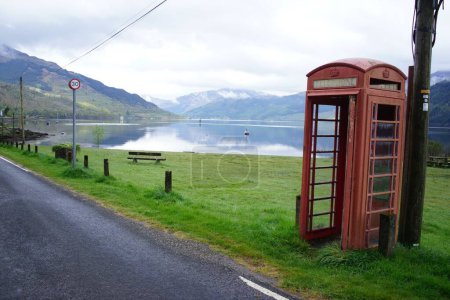 Foto de Una cabina telefónica roja rural Escocia Loch Goil en la arena de gras por una carretera - Imagen libre de derechos