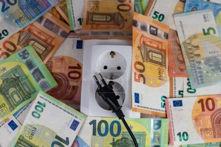 Téléchargez les photos : Une prise électrique parmi de nombreux billets de 50, 20, 5 et 100 euros - en image libre de droit