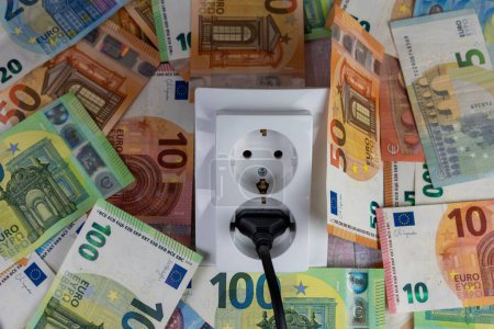 Téléchargez les photos : Une prise électrique sur la monnaie des billets en euros, la hausse des prix de l'électricité crise - en image libre de droit