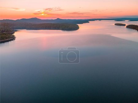 Photo for A bird's eye view of a lake surrounded by trees at sunset - Royalty Free Image