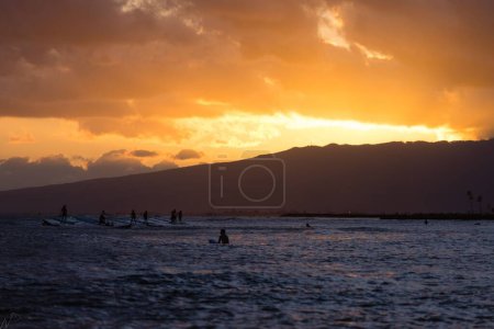 Téléchargez les photos : La silhouette des surfeurs au coucher du soleil à Waikiki Beach, Honolulu, Hawaï USA - en image libre de droit