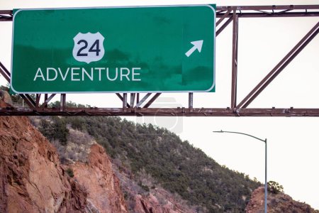 Téléchargez les photos : Une vue rapprochée d'un panneau d'autoroute d'aventure sur l'autoroute de montagne - en image libre de droit