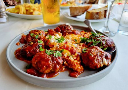 Téléchargez les photos : Un gros plan de délicieuses boulettes de viande avec sauce tomate sur la table dans un restaurant grec - en image libre de droit