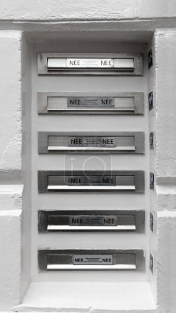 Photo for A grayscale vertical shot of letterboxes row in old plastered wall - Royalty Free Image