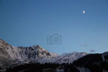 Téléchargez les photos : Une vue panoramique d'une chaîne de collines enneigées le soir - en image libre de droit