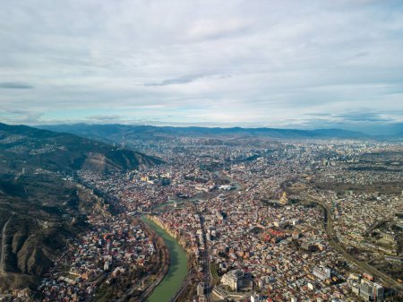 Téléchargez les photos : Une vue aérienne du paysage urbain de Tbilissi avec des montagnes vertes avec un ciel nuageux bleu en Géorgie - en image libre de droit