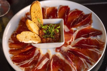 Téléchargez les photos : Une assiette de jamon avec crosinis sur une table de restaurant - en image libre de droit
