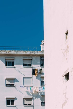 Photo for A vertical shot of a white residential building with hanging laundry - Royalty Free Image