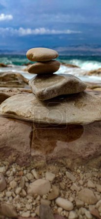 Téléchargez les photos : Un gros plan vertical sélectif de roches empilées les unes sur les autres sur la plage - en image libre de droit