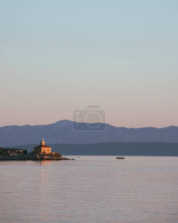 Téléchargez les photos : Vue verticale d'un paysage marin avec un phare au crépuscule à Makarska, Croatie - en image libre de droit
